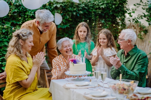 An elderly lady having a birthday party with her family.