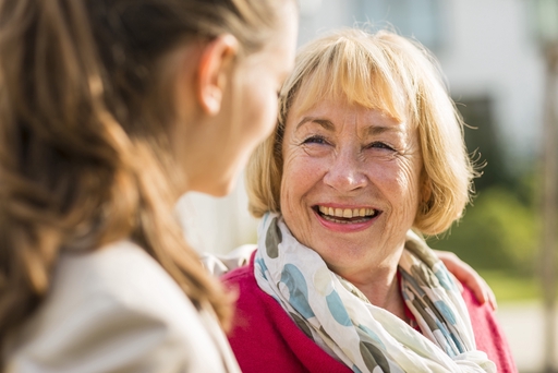 An elderly woman smiling with a live-in carer.