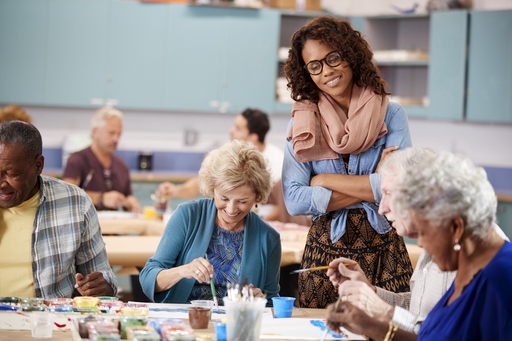An art teaching overlooking her elderly students at a day centre