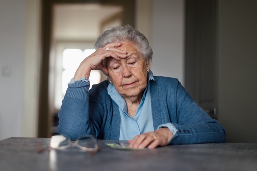 An old lady looking tired sat at a table