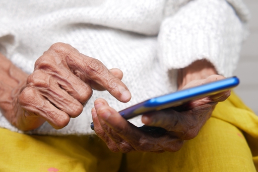 Elderly persons hands holding a phone