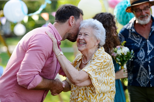 An elderly lady being greeted by a friend or relative.